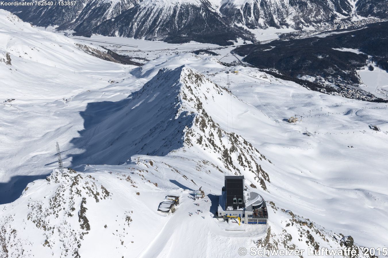 Piz Nair (Restaurant) auf 3024 m.ü.M.; Blick ins Skigebiet 'Valletta da la Pêsch' und Marguns links, Corviglia rechts. Engadin mit Flugplatz Samedan.